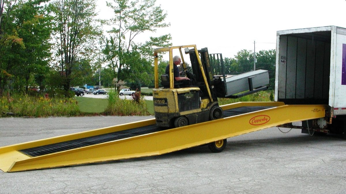 A forklift using one of Copperloy's hydraulic forklift ramps.